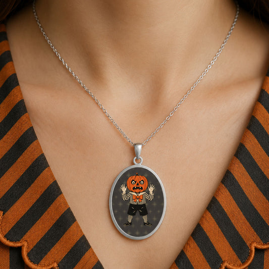 Stainless steel oval pendant necklace with pumpkin-headed figure on dark background