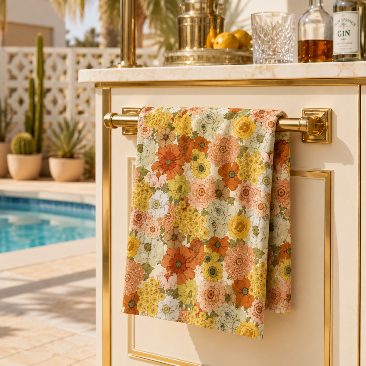 Floral kitchen towel hanging on a gold bar, yellow and orange flowers on cream